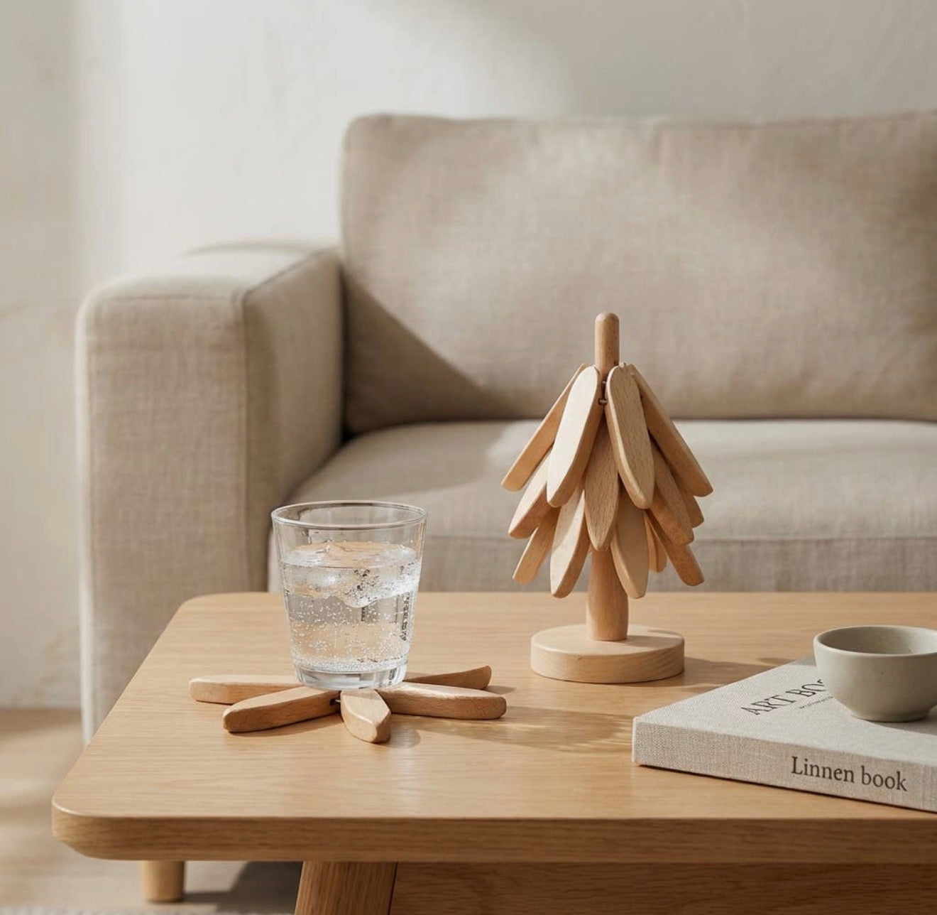 The Grove in Morning on a coffee table beside a glass of sparkling water and a stack of books.