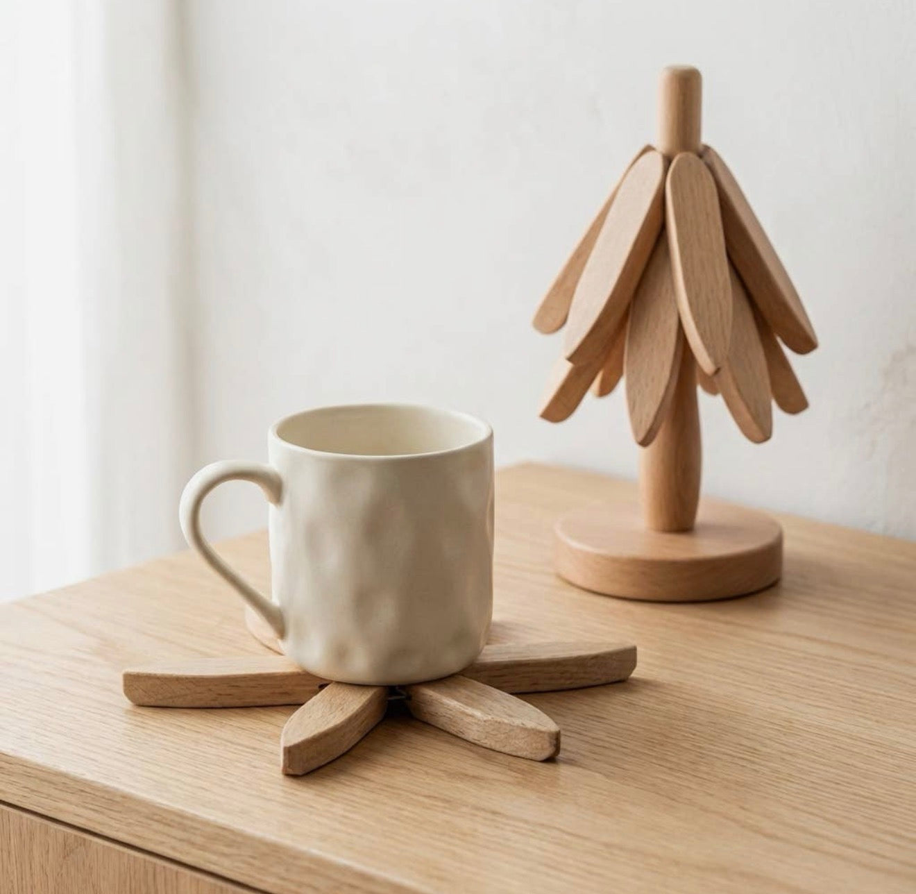 A Morning coaster from The Grove under a white mug, with the tree standing behind.
