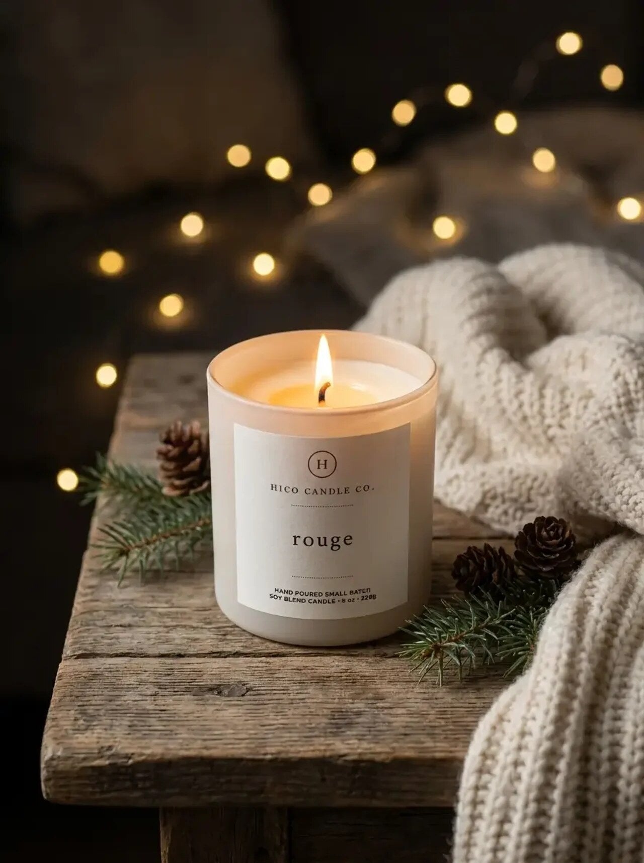 Hico Rouge candle among warm string lights and a knit throw.