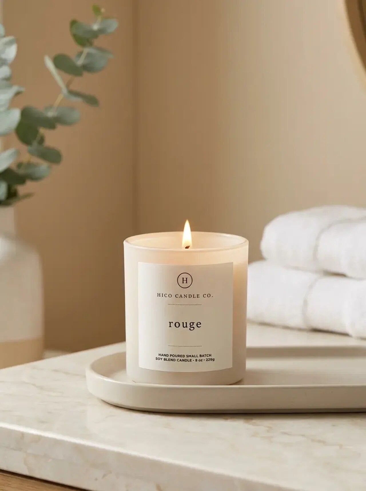 Hico Rouge candle on a tray with folded towels.
